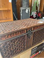 Front angle showing the wicker style wood chest with detailed weaving and metal latch
