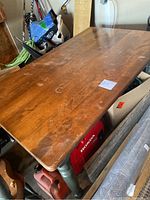Photo of the wooden kitchen table displaying the rectangular tabletop with visible scratches and stains.