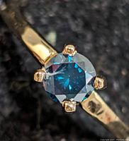 Close-up of round blue diamond and four-prong setting