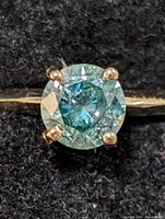 Top-down view of the ring showing round moissanite gemstone and four-prong setting