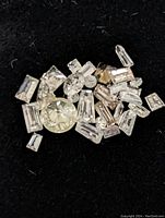 Close-up of various loose diamonds on black felt background showing different cuts and clarity.