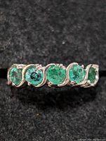 Photo showing the sterling silver ring from a top angle with emerald stones visible.