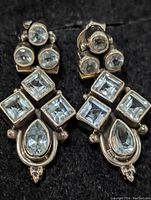 Close-up photo of the pair of sterling silver earrings with aquamarine stones, showing the front and details of the gemstones and setting.