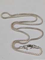 Sterling silver chain necklace laid out showing full length and lobster clasp.