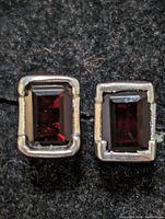 Close-up of the garnet stones set in silver bezels, showing the deep red rectangular cut and the silver framing.