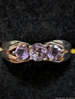 Close-up view of sterling silver amethyst ring on black fabric background showing front detail