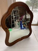 Front view of the antique vanity mirror showing the wooden frame and reflective glass surface.