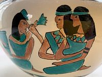 Close-up showing hand-painted Egyptian figures on the vase, highlighting brushwork and colors.