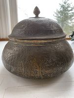 Full side view of the brass jar showing shape and engraved figure and foliage details.