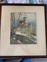 Full view of the framed coloured print showing a castle landscape, with trees and hill.