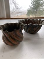 Photo of two small handmade copper bowls showing fluted design and scalloped edges