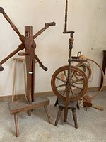 Full view showing both the spinning wheel and wool winder side by side in a neutral indoor environment