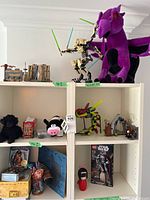 Overall view of shelving units displaying plush toys, Lego Star Wars builds including battle droid, and smaller collectible items