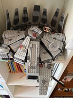 Lego Millennium Falcon model displayed on a shelf, top view showing intricate detailing and paneling.