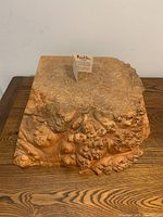 Side view of large decorative birds eye maple burl wood box showing natural wood grain texture and front side detail.