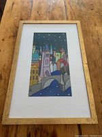 Framed pastel painting showing Charles Bridge and the Prague skyline at night with stars over a blue river.