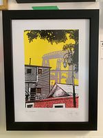 Framed serigraph artwork showing urban Buenos Aires scene with buildings, street lamp, and bridge in background.