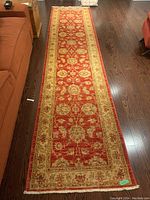 Full-length top view of the red and beige runner on hardwood floor