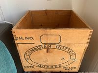 Front view of vintage wooden crate with printed text 'Canadian Butter Quebec 56 lbs Net'.