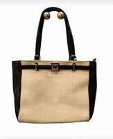 Front view of the Kate Spade tote bag showing beige wicker panel, black leather sides and black leather straps with gold clasp.