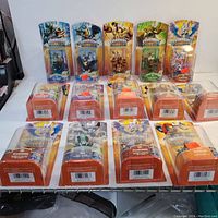 14 Skylanders Giants figures in original blister packaging arranged on surface with both front and top views showing character designs and packaging condition.