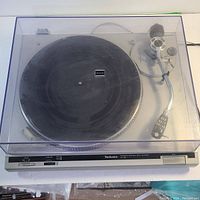 Full front view of Technics SL-B2 turntable with dust cover on, showing platter and tonearm.