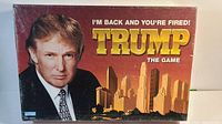 Front of sealed Trump The Game box featuring Donald Trump and city skyline, branding, and slogan.
