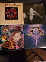 Four vinyl LP records including Best of Toto, Dire Straits Love Over Gold, Culture Club Colour By Numbers, and Toto album with sword logo.