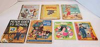 Front view showing title and cover art of 7 assorted children's books from mid 20th century