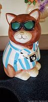 Ceramic bear cookie jar with blue and white striped shirt, black sunglasses, and a camera around its neck.