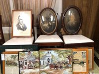 Group of framed wall art including oval portrait frames and rectangular prints with vintage automotive theme.