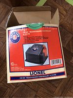 Top view of the open cardboard box showing the Lionel CW-80 Transformer/Controller and branding with image and features.