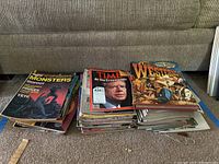 Photo showing three stacks of magazines including Monster, Time, and a thick book titled 'A Pictorial History of Westerns'