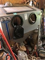 Front view of the dry blast cabinet showing the glove ports and viewing window.