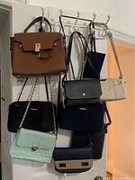 Wide shot of assorted purses hanging on wall hooks