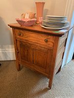 Side view of the wooden antique side table with drawer and cabinet, showcasing the table's design and wear.