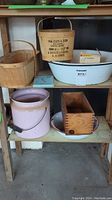 Shelf with wooden baskets, large white metal tub, pink crock, wooden box and tin