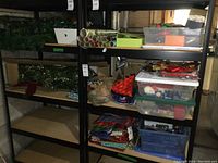Shelves full of assorted Christmas decorations including garland, wreaths, wrapping paper, lights, bows, bags, and stockings.