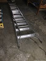 Full view of the multi ladder extended on the floor showing the ladder's length and frame.