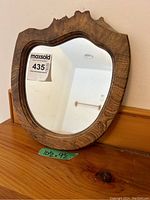 Front view of the burr ash wood framed mirror with price tag and size label
