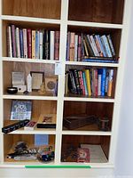 Full view of shelves with books, cards, spiritual items, crystals, feathers and meditation statues