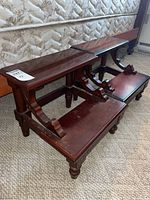 Front angle of both stools displaying two-tier design and carved brackets