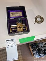 Full lot with thread counter in case and separate brass magnifier on white surface.