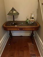 Full desk view with leather top inset and two drawers, carved legs visible