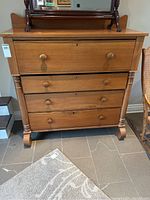 Front view of the wooden 4-drawer dresser showing drawer knobs and overall finish.