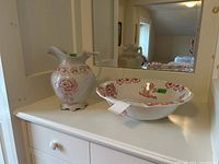 Ewer and basin on white surface with mirror background, showing general appearance and pattern.