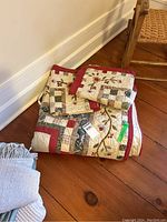 The folded quilt and matching shams with visible patchwork and floral embroidery designs.