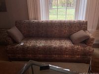 Front view of multi-coloured sofa in front of window.