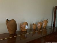 Five wooden bird sculptures arranged in a row on a wood surface