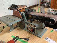 Overall view of Delta belt and disc sander with power cord and tables visible